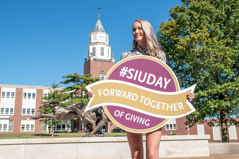 Student holding day of giving sign